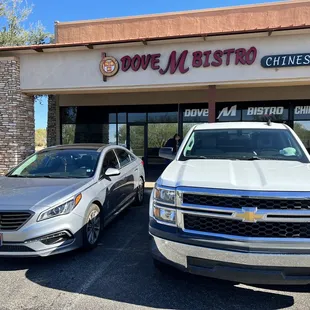two vehicles parked in front of a chinese restaurant