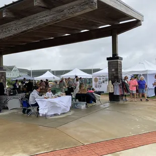 Farmers&apos; Market booths under the pavilion and bordering the grassy common.