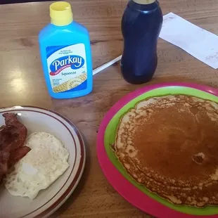 a plate of pancakes, bacon and eggs