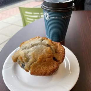 a blueberry muffin and a coffee cup