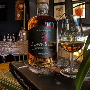 a glass of whiskey and a book