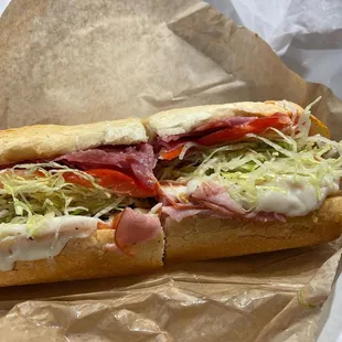 a sub sandwich with lettuce, tomato, and cheese