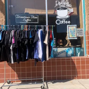 clothing on a rack in front of a coffee shop