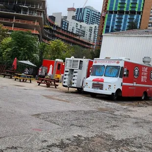 a row of food trucks parked in a parking lot
