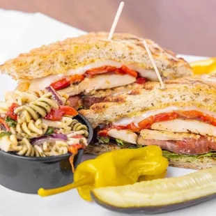 a grilled chicken sandwich with a side of pasta salad