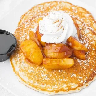 a pancake with peaches and whipped cream