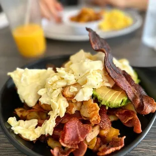 a plate of bacon, eggs, and hash browns