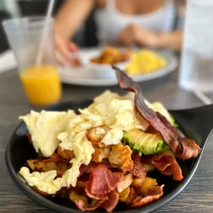 a plate of bacon, eggs, and avocado