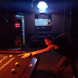 a man leaning over a pool table