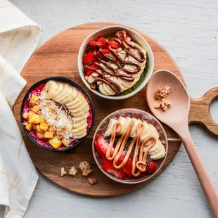 three bowls of fruit and yogurt
