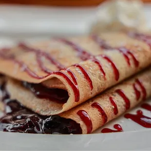 a plate of crepes with whipped cream