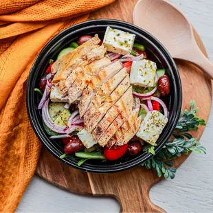 a bowl of salad with grilled chicken
