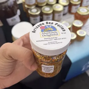 a hand holding a jar of honey