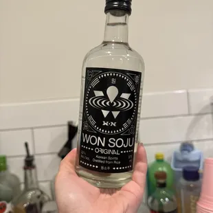 a hand holding a bottle of woni soul gin