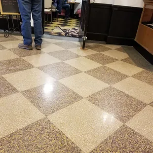 a man standing in the middle of a checkered floor