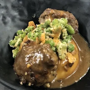 Aussie Rissoles with mashes potatoes, Parmesan edamame and savory gravy.