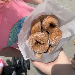 a person holding a bag of donuts
