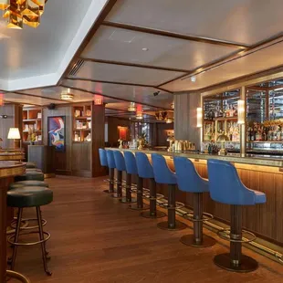 a bar with stools and a bar counter