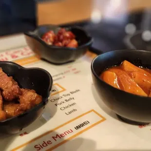 Side dishes of soy fried pork belly and tteokbokki