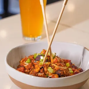 a bowl of food with chopsticks