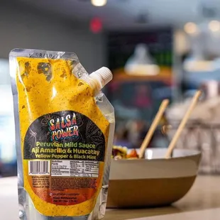 a bag of sauce next to a bowl of sauce