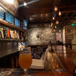 a glass of beer on a bar counter