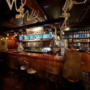 a bar with skeletons hanging from the ceiling