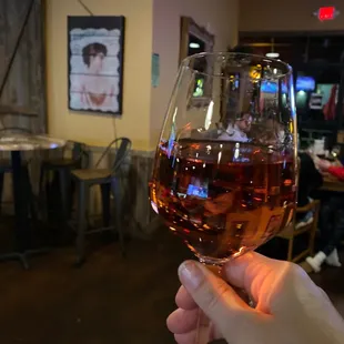 a hand holding a glass of wine