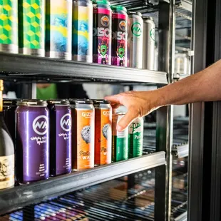 a man reaching for a can of beer