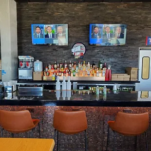a bar with three televisions on the wall