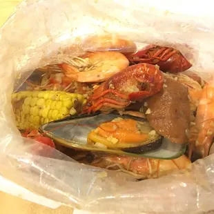 shrimp, musselling, corn, corn and musselling in a plastic bag