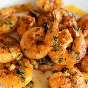 a plate of cooked shrimp with a lemon wedge