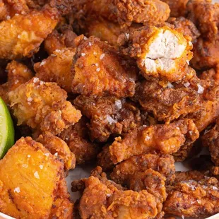 a bowl of fried chicken with a lime wedge