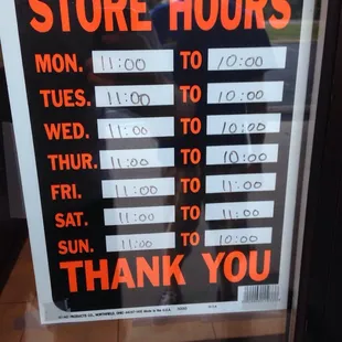 a store hours sign in a window
