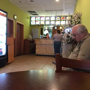 a man sitting at a table in front of a vending machine