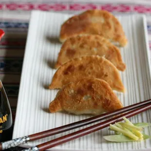 a plate of dumplings and chopsticks