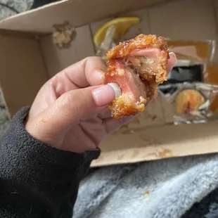 a hand holding a half eaten donut