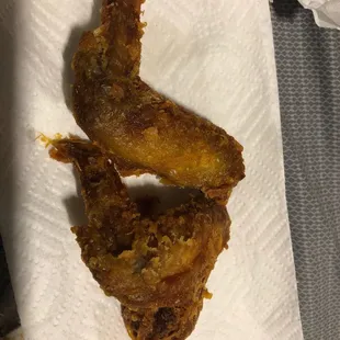 two pieces of fried chicken on a napkin