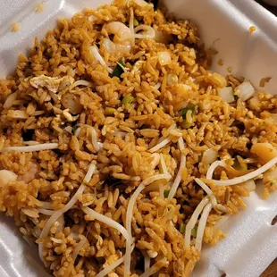 a close up of a rice dish in a styrofoam container