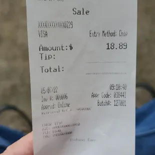 a hand holding a receipt