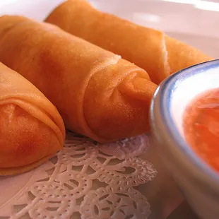 a plate of hot dogs with dipping sauce