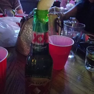 a bottle of beer with an apple on top