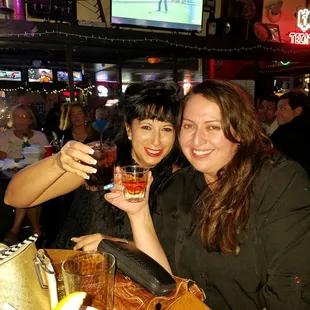 two women toasting at a bar