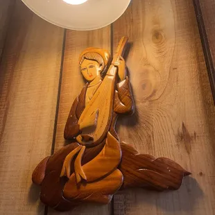 a wood carving of a man holding a sword