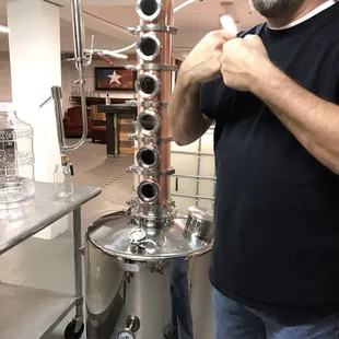 a man standing in front of a stainless steel vessel