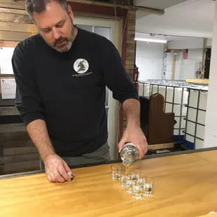 a man pouring water into glasses