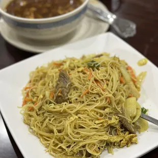 a plate of noodles and a bowl of soup