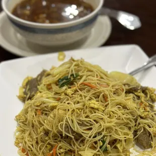 a plate of noodles and a bowl of soup