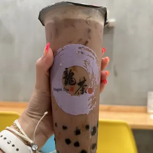 a hand holding a cup of bubble tea