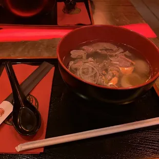 a bowl of soup and chopsticks